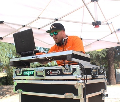 DJ Ravick playing an outdoor event beneath a canopy